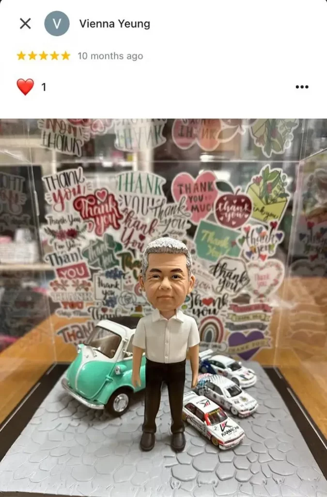 一件極具心思的男士榮休禮物。一個銀髮男性人像公仔,身穿白色Polo衫,站在一個擺放了四輛模型車(一輛復古車和三輛賽車)的地台上。整個作品最引人注目的背景是一面貼滿了各式各樣「Thank You」感謝字樣貼紙的感謝牆,表達了濃厚的感激之情。