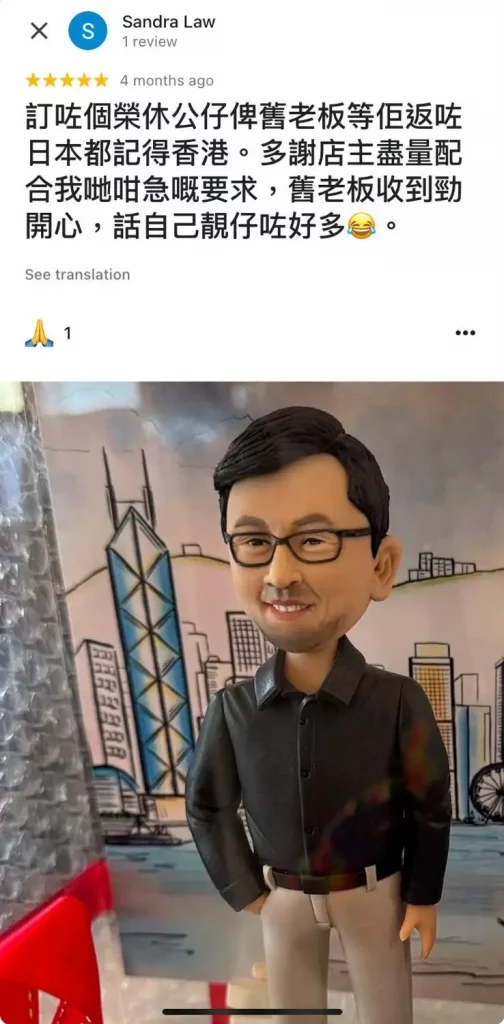 一件送給即將返回日本的上司的榮休禮物。一位戴眼鏡的男士人像公仔,面帶微笑站立著。背景是一幅手繪風格的香港城市景觀,以標誌性的中銀大廈為中心,寓意讓他永遠記得在香港的時光。