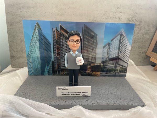 為感謝項目主管Dickson Wat卓越領導而客製的人形公仔，背景板展示了他負責的建築項目，是一份極具意義的離職禮物。這款體面的farewell禮物，也適合作為上司的榮休禮物或退休禮物，以紀念其事業成就。這也是工程師禮物