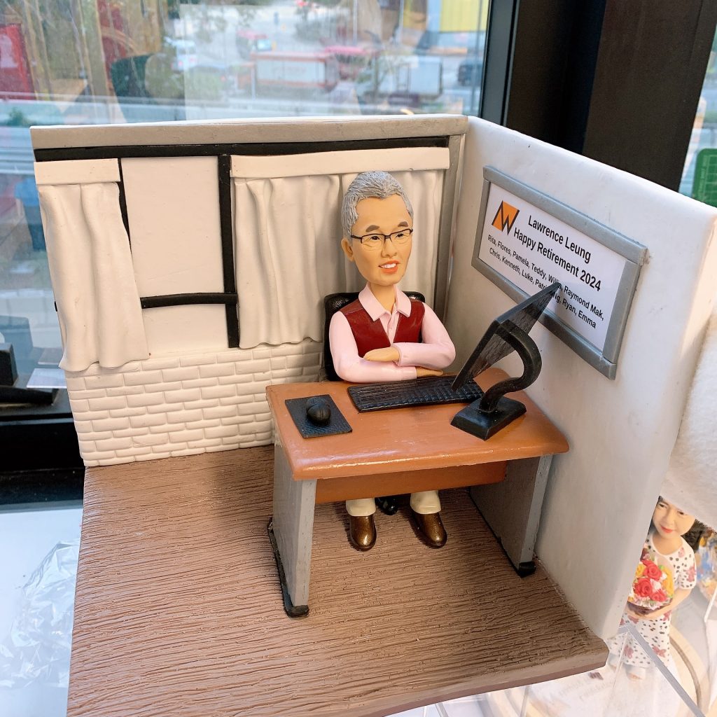 "一件送給男性上司的榮休禮物。一位滿頭銀髮、戴眼鏡的人像公仔，穿著毛衣背心，雙手抱胸自信地坐在辦公桌前。背景是一個溫馨的辦公室角落，牆上掛著一塊寫有祝福語的銘牌，整個場景充滿了對這位睿智領導的敬意。