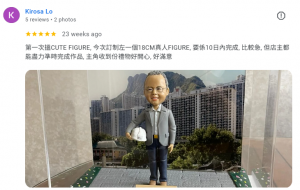 一個細緻的人像公仔作為退休禮物，手持金門建築有限公司安全帽，微笑站立於黃大仙與獅子山的標誌性天際線前，象徵榮譽退休與客人滿意的回憶。