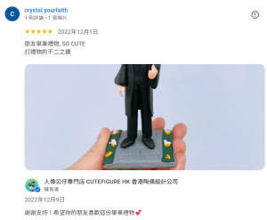 一個戴眼鏡、穿著黑色畢業袍和四方帽的人像公仔，站在有花朵裝飾的底座上，被手掌托起，造型可愛，獲得客人五星好評。
