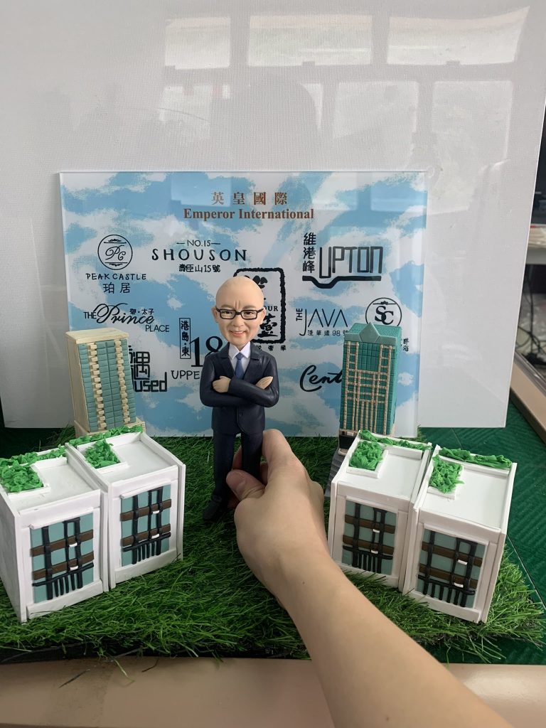 男士人像軟陶公仔站在多棟寫字樓模型之間，適合作為退休禮物或榮休禮物，為老闆或上司留下難忘回憶。