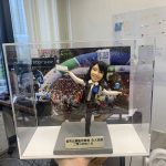 以手作定格高光時刻：這款警察人像公仔採用動態展臂站姿與單腳微踮設計，臉部眉眼弧度、嘴角微笑、髮絲刻線和背心/襯衫的摺痕都逐一刻畫。背板選用大型活動現場影像，與透明展示盒共同營造儀式感；灰色質感底座與金色牌匾則強化典藏層次。無論作為升遷誌慶、團隊紀念，或致謝同事的專屬送禮，皆能體現專屬故事與心意。