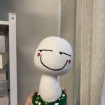 一款根據網絡顔文字設計的表情包立體公仔，白色蘑菇造型帶有得戚的微笑表情，是送給朋友的創意人像公仔生日禮物。