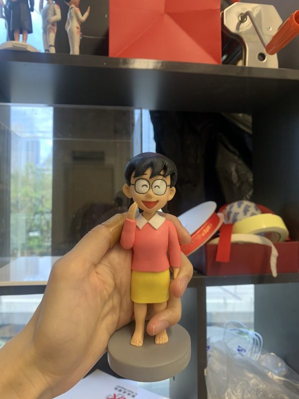 一款根據經典動漫人物《多啦A夢》中野比玉子形象製作的人像公仔，她身穿粉紅上衣和黃色短裙，是充滿童年回憶的生日禮物。