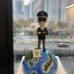 一款為機師退休設計的人像公仔，公仔身穿機師制服、戴太陽眼鏡，充滿自信地站在地球模型上，底座寫有「Happy Retirement 2024」，是完美的機師退休禮物。