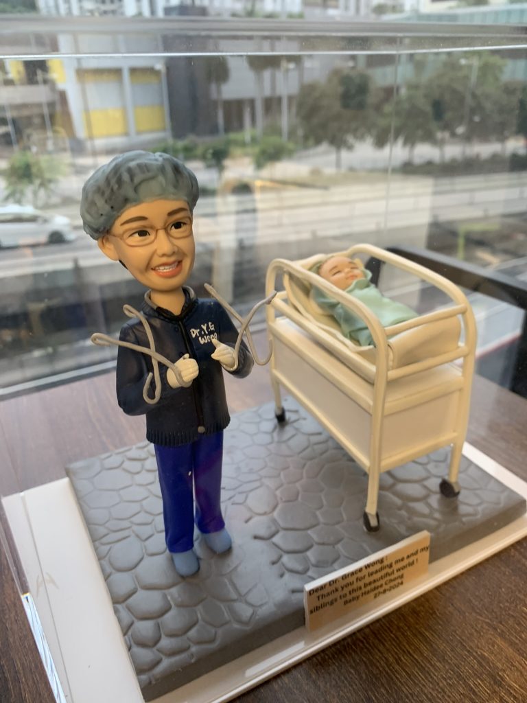 一款送給婦產科接生醫生黃醫生（Dr. Grace Wong）的醫生答謝禮物。精緻的人像公仔身穿手術服，微笑著站在一張嬰兒病床旁邊，床裡躺著一個新生嬰兒，銘牌上刻有來自嬰兒家庭的感謝語，是一份充滿溫情的紀念品。