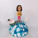 一款送給外國同事的退休禮物，一位女士人像公仔站在地球模型上，地球上有香港的天星小輪模型和新加坡的魚尾獅模型，象徵著兩地的美好回憶。