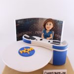 新聞演播室主題人像公仔：短髮女性報導員穿藍色上衣，坐在弧形主播台後方，桌面有麥克風與鍵盤；背板為新聞頻道演播室背景，前方白色圓台上有藍底黃字標誌；米色底座前擺有「Cutefigure_hk」名牌。整體專業而典雅，適合作為新聞部報導員退休禮物與榮退紀念擺設。