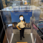 這是一款精心定製的香港警察專屬人像公仔，身穿輔警制服，肩上配有步槍，細節處理極為逼真，從警徽到制服線條均一絲不苟。公仔被安置於透明展示盒中，背景是印有「香港輔助警察隊」字樣與香港天際線的設計，突顯警隊守護社區的責任與使命。整體造型既專業莊嚴，又帶有收藏與紀念的意義，成為一份別具心意的專屬禮物。