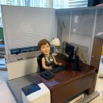 老闆｜退休禮物｜人像公仔推薦：女老闆公仔坐在辦公椅後，搭配深棕辦公桌、雙螢幕、鍵盤滑鼠與印表機，背景為玻璃隔間與百葉窗，名牌標示公司名稱，完整呈現她的辦公室日常；支援客製姓名、職銜、年份與場景配件，將專業與回憶一次收藏。Keywords：老闆，退休禮物，人像公仔。