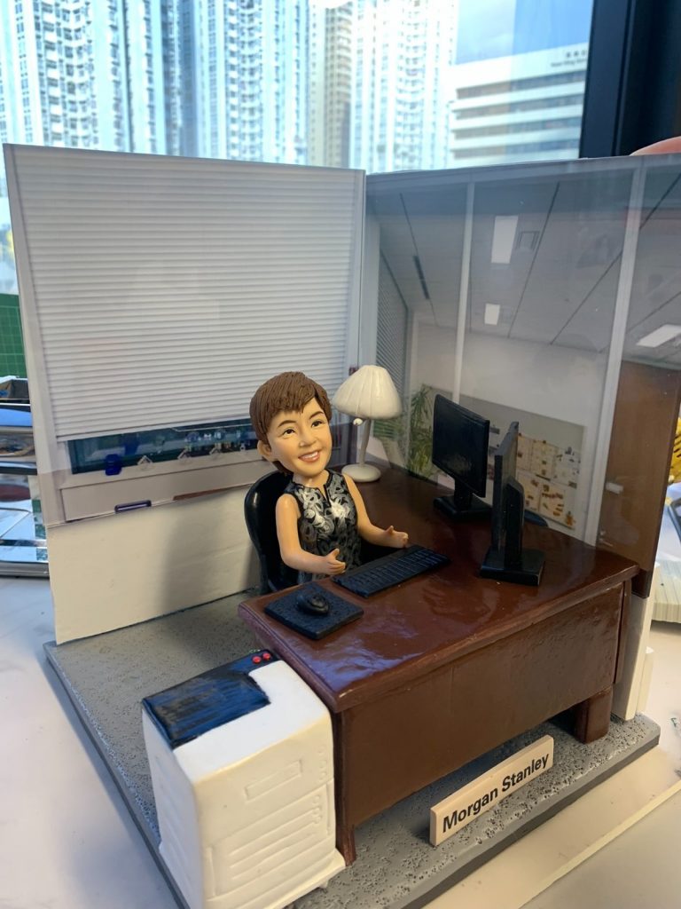 老闆｜退休禮物｜人像公仔推薦：女老闆公仔坐在辦公椅後，搭配深棕辦公桌、雙螢幕、鍵盤滑鼠與印表機，背景為玻璃隔間與百葉窗，名牌標示公司名稱，完整呈現她的辦公室日常；支援客製姓名、職銜、年份與場景配件，將專業與回憶一次收藏。Keywords：老闆，退休禮物，人像公仔。