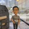 一款為聖類斯中學的黎德維校長（Mr. Lai Tak Wai）訂製的校長退休禮物。精緻的人像公仔手持數學書，莊重地站在一座細節豐富的聖類斯中學立體學校模型旁，底座前方陳列著五個社（LILY, ROSE, SHAMROCK, THISTLE, TULIP）的標誌，整件作品置於透明保護罩中，是一份極具份量的榮休紀念品。