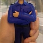 一款為香港消防員訂製的升職人像公仔，公仔身穿藍色工作制服，由其駐守的尖沙咀消防局B隊全體隊員敬贈，祝賀其榮陞。