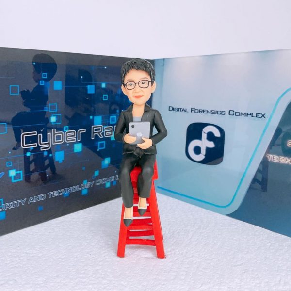 科技罪案與數位鑑識主題的人像公仔：短髮戴眼鏡的角色身著黑色西裝，手持平板坐在鮮紅色高腳凳上；背板左側為深藍數位網格與電路紋理設計，標示 Cyber Range 與 Cyber Security and Technology Crime Bureau 字樣；右側為淺灰藍色走廊與 Digital Forensics Complex 標誌，並見 Cyber Security and Technology Crime Bureau 的牆面標示。地面為白灰色細點質感，整體呈現與【鑑證科】、數位鑑識或科技罪案調查相關的警察單位氛圍，適合作為警務人員禮物或警察人像公仔的專業場景。