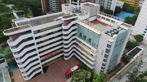 港大同學會小學外觀，一座多層白色建築，設有弧形走廊和綠色運動場，適合慶祝校長退休的紀念品。