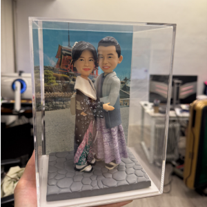 這款作品以情侶身穿 日本和服 為主題，完美重現浪漫的旅拍時刻。 男女主角身著典雅的和服套裝，色調柔和而具層次感， 女方以髮飾點綴，氣質嫻雅，男方神情溫暖沉穩， 兩人相擁而立，展現濃厚的幸福氣息與默契感。 背景以日式建築景象為襯托，營造悠然的異國氛圍； 腳下鋪有石板路台，細節紋理清晰，整體構圖平衡自然。 作品以透明展示盒裝嵌，兼具收藏與展示價值。 此設計特別適合作為 情侶紀念日、結婚紀念或旅拍紀念禮物， 以立體公仔形式凝結專屬的甜蜜回憶， 讓每一段愛的旅程都被溫柔珍藏。