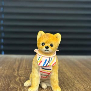 這款狗狗造型的客製化寵物公仔，由 CUTEFIGURE HK 團隊全手工製作，以安全無毒的軟陶材料雕塑出細膩的毛髮紋理與自然姿態。公仔採用坐姿設計，搭配色彩繽紛的圍巾，營造俏皮又溫馨的氛圍。每隻寵物公仔皆以相片作藍本，手工捏製比例、體態、毛色與獨特特徵，確保能忠實呈現愛寵獨一無二的個性。