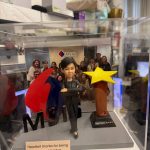 CUTEFIGUREHK 客製化女性上司人像公仔，裝在透明亞加力防塵展示盒內。公仔身穿黑色西裝，雙手交叉展現自信的領袖風範。場景內配有立體 MSIG 公司標誌及「Best Boss Award」星形獎座，底座設有印上「Heartfelt thanks for being our great leader!」的專屬木紋牌匾，背景更加入了團隊大合照，是一份極具心思的企業紀念品。