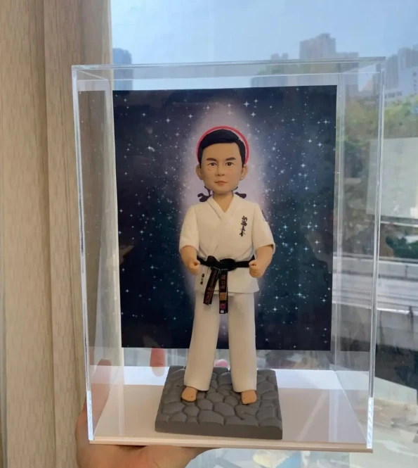 一位空手道師傅的人像公仔，他身穿道服繫著黑帶，莊嚴地站立在星空背景前。整個作品收藏在透明展示盒中，是一份充滿敬意的跆拳道禮物或榮休禮物。