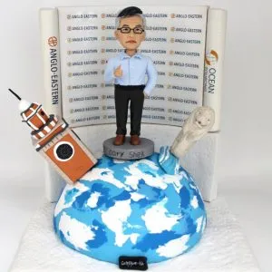 一款慶祝男士退休的人像公仔，他站在地球模型上，背景是公司LOGO背景牆，旁邊還有香港鐘樓和新加坡魚尾獅的立體建築物模型。
