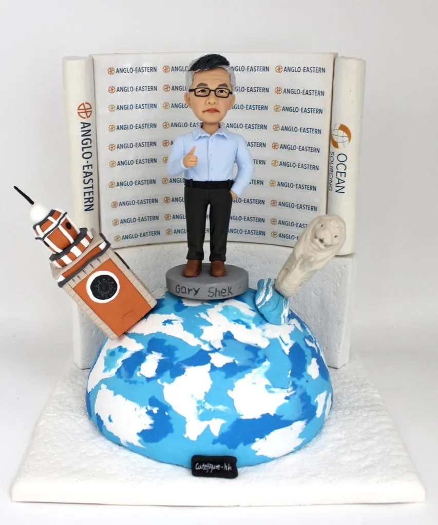 一款慶祝男士退休的人像公仔，他站在地球模型上，背景是公司LOGO背景牆，旁邊還有香港鐘樓和新加坡魚尾獅的立體建築物模型。