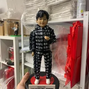 香港歌手胡鴻鈞（Hubert Wu）的訂製人像公仔，公仔身穿印滿其英文名的黑色舞台服飾，站在刻有其演唱會名稱的心形底座上。