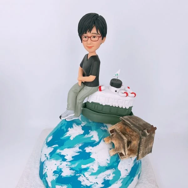 一款客製化的女士退休禮物，一位女士人像公仔悠閒地坐在香港天星小輪模型上，旁邊有一座精緻的木屋建築模型，整個場景設置在地球模型底座上，是送給女同事的完美選擇。