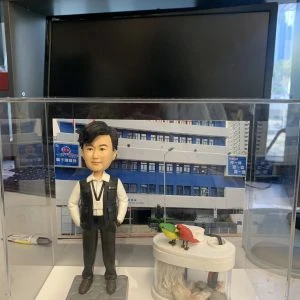 一款為香港警務人員訂製的晉升人像公仔，主角為一名身穿戰術背心的警官，旁邊配有一個帶愛情鳥的魚缸配件裝飾，背景為警署照片。