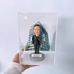 以黑色禮式制服呈現專業與榮譽，這款警察人像公仔置於透明亞加力展示盒，前牌刻上「Happy Retirement」祝福語，背板採用現代高層建築圖像，象徵城市服務場景。細節包含肩章、對講機與裝備刻畫，極具收藏與致敬意義，作為升遷或榮休禮物皆合適。