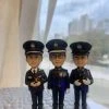 一款為三位高級警務人員訂製的晉升或退休禮物，包含三個身穿警隊禮服的人像公仔，站立在香港警察總部背景前，旁邊有一輛黑色座駕模型車。