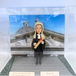 一款女性資深大律師人像公仔，身穿律師袍、頭戴假髮，站立在香港終審法院背景前，是慶祝法律畢業或晉升的完美祝賀禮物及畢業禮物。