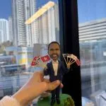 一款為外國老闆訂製的退休禮物人像公仔，公仔身穿西裝，手持由香港及亞洲各國國旗組成的扇子，是送給老闆退休的完美歡送禮物。