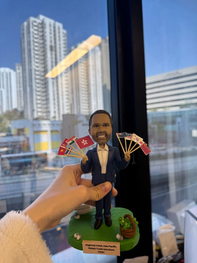 一款為外國老闆訂製的退休禮物人像公仔，公仔身穿西裝，手持由香港及亞洲各國國旗組成的扇子，是送給老闆退休的完美歡送禮物。