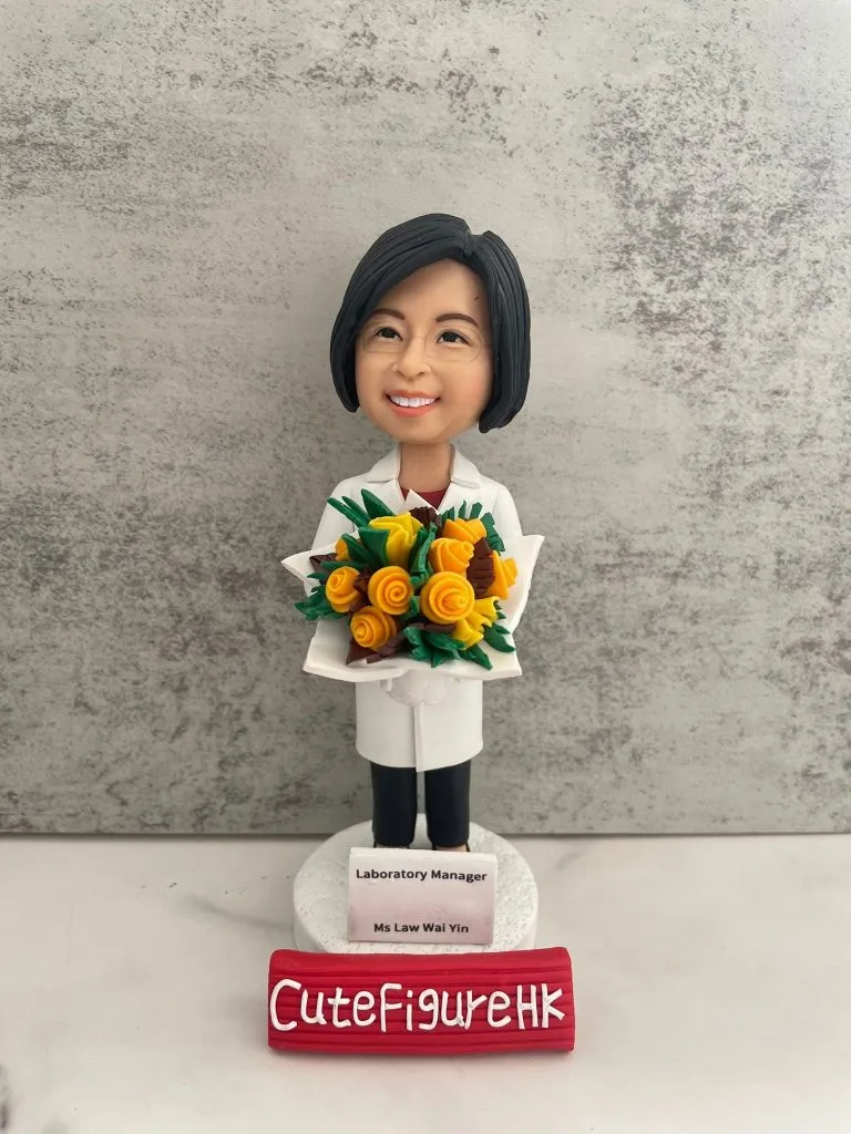 定製醫護人像公仔，角色為實驗室主管 Ms Law Wai Yin，身穿白袍，手捧鮮花，底座刻有「Laboratory Manager」字樣。此公仔象徵醫護專業及實驗室醫生/醫療管理人員的專業身份，是醫院或科研機構專屬的退休與感謝禮物。
