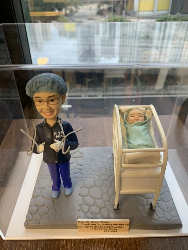 一款送給婦產科接生醫生黃醫生（Dr. Grace Wong）的醫生答謝禮物。精緻的人像公仔身穿手術服，微笑著站在一張嬰兒病床旁邊，床裡躺著一個新生嬰兒，銘牌上刻有來自嬰兒家庭的感謝語，是一份充滿溫情的紀念品。