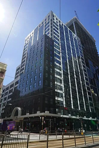 友邦保險 (AIA) 位於香港中環的總部大樓外觀，藍色玻璃幕牆在陽光下閃耀，為公司輝煌生涯的象徵。