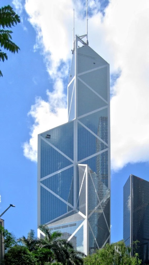 香港中銀大廈的標誌性建築外觀，鋼骨結構與玻璃帷幕在藍天白雲下閃耀，展現金融精英的專業形象。