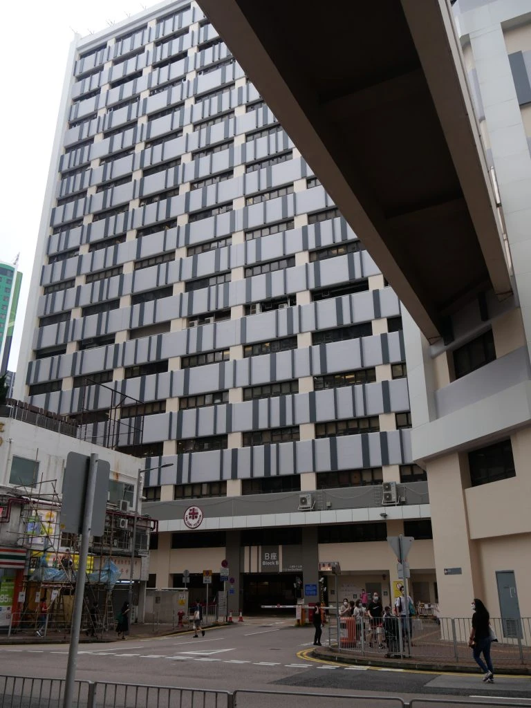 仁濟醫院大廈外觀，灰色與米白色相間的窗戶和外牆，底部是醫院入口和馬路，彰顯機構榮譽。