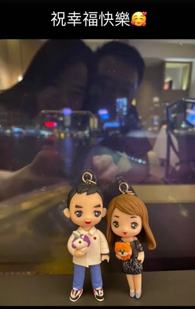 一對Q版真人公仔情侶站在餐廳窗邊，窗戶倒影出真實情侶的甜蜜合照，男公仔手抱獨角獸，女公仔手抱小獅子，將瞬間鑄造成信物。