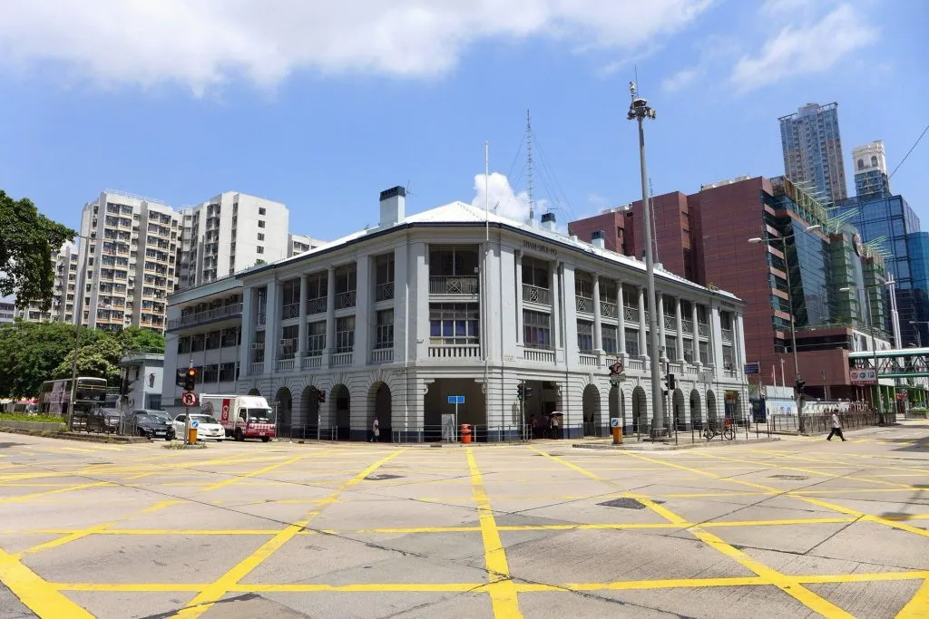 香港深水埗警署的白色建築物，位於繁忙的十字路口，展現紀律部隊的專業氣場。