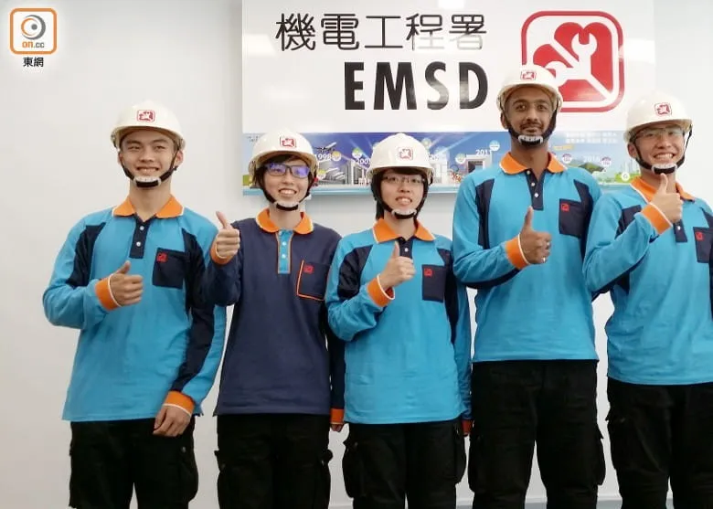 五位穿著機電工程署制服的員工戴著安全帽，豎起拇指，笑容滿面地合照，象徵事業有成，是送給退休男士的祝福禮物。