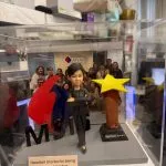 CUTEFIGUREHK 客製化女性上司人像公仔，裝在透明亞加力防塵展示盒內。公仔身穿黑色西裝，雙手交叉展現自信的領袖風範。場景內配有立體 MSIG 公司標誌及「Best Boss Award」星形獎座，底座設有印上「Heartfelt thanks for being our great leader!」的專屬木紋牌匾，背景更加入了團隊大合照，是一份極具心思的企業紀念品。