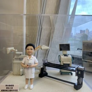 手工訂製醫護人像公仔，人物身穿白色醫護制服，站立於精緻的手術室場景模型中。背景包括手術燈、醫療儀器及手術檯，細節逼真。底座文字顯示：「黎永勤經理 經休之喜 威爾斯親王醫院手術室」，象徵專屬醫生與醫護人員的定製禮物，用於紀念醫療團隊的專業與感謝之情。