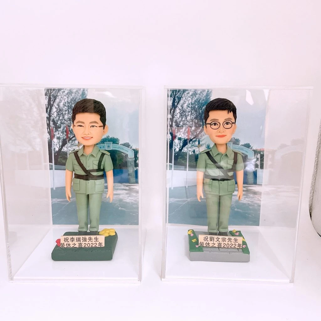 兩款為香港警務人員訂製的榮休人像公仔，公仔身穿淺綠色復古警隊制服，分別放在獨立的透明展覽盒中，用以紀念他們在2022年一同光榮退休。
