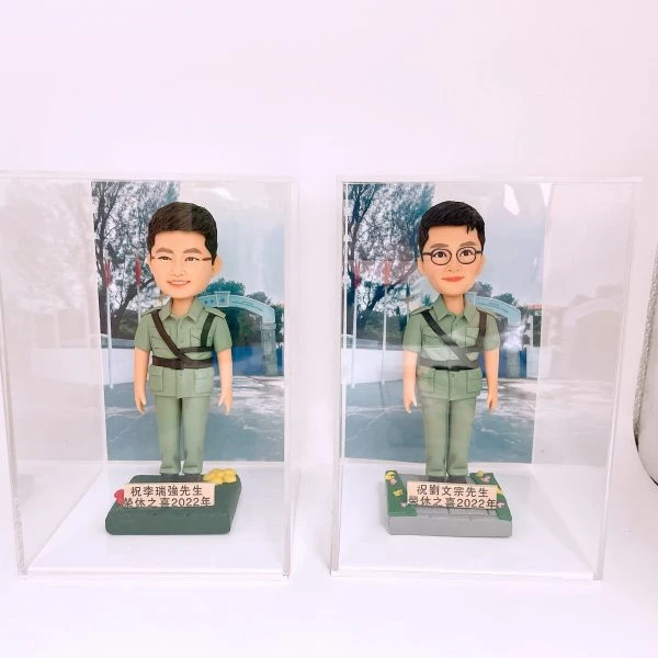 兩款為香港警務人員訂製的榮休人像公仔，公仔身穿淺綠色復古警隊制服，分別放在獨立的透明展覽盒中，用以紀念他們在2022年一同光榮退休。