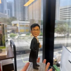 一款男士律師人像公仔，身穿律師袍站立在刻有姓名和日期的底座上，是慶祝律師資格考試紀念的完美祝賀禮物和律師禮物。