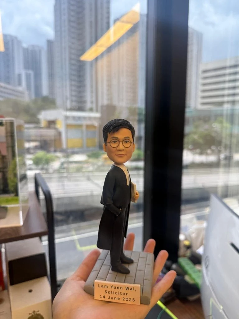 一款男士律師人像公仔，身穿律師袍站立在刻有姓名和日期的底座上，是慶祝律師資格考試紀念的完美祝賀禮物和律師禮物。